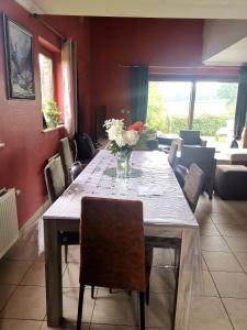 - une table à manger avec un vase de fleurs dans l'établissement Mevazara guesthouse, à Malmedy