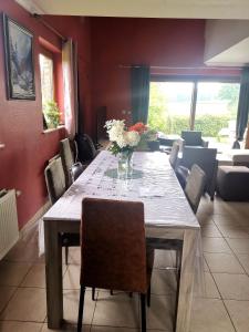 a dining room table with a vase of flowers on it at Mevazara guesthouse in Malmedy