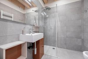 La salle de bains est pourvue d'un lavabo et d'une douche. dans l'établissement Palazzo '900 Design Flats - Il Poeta, à Padoue