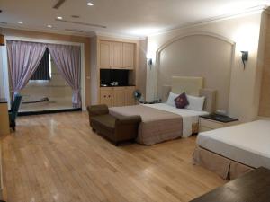 a large hotel room with two beds and a couch at Lisa Motel in Kaohsiung