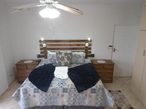 a bedroom with a bed and a ceiling fan at Dolphin Den in Port Shepstone