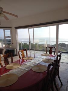 a dining room table with chairs and a view of the ocean at Dolphin Den in Port Shepstone