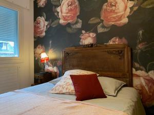 - une chambre avec un lit et du papier peint à fleurs dans l'établissement Chez Paul et Louis, à Rodez