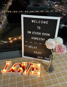 a welcome sign and a vase with flowers and candles at Damen Suite Sunway Subang by DW in Subang Jaya