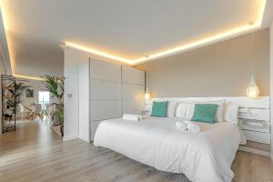 sypialnia z dużym białym łóżkiem z zielonymi akcentami w obiekcie Pámpano Ocean View w Puerto de la Cruz