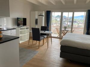 ein Schlafzimmer mit einem Bett und einem Schreibtisch sowie eine Küche in der Unterkunft Studio Bergblick in Eschenbach