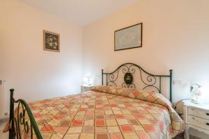 een slaapkamer met een bed met een quilt bij Papà Giuseppe La Stalla in Cortona