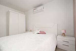 ラゴアにあるNuno & Daisy Apartamento Lagoaの白いベッドルーム(白いベッド1台、白いキャビネット付)