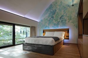 - une chambre avec un grand lit orné d'une peinture murale dans l'établissement VERSOVERDE HOTEL Alzaia Naviglio Grande, à Milan