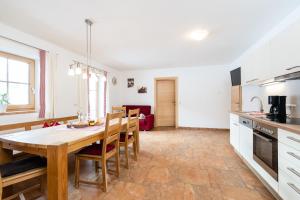 uma cozinha e sala de jantar com uma mesa de madeira e cadeiras em Ferienwohnung am Waldrand em Mittersill