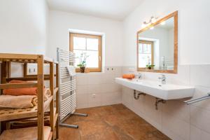 uma casa de banho com um lavatório e um espelho em Ferienwohnung am Waldrand em Mittersill