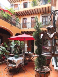 a patio area with tables, chairs and umbrellas at Hotel Boutique Parador San Miguel Oaxaca in Oaxaca City