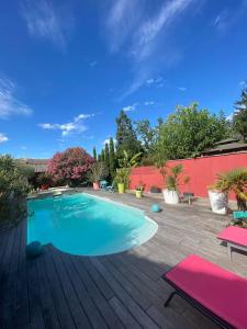 una piscina en un patio trasero con terraza de madera en Appartement 45m2 à Bordeaux avec accès piscine, en Burdeos