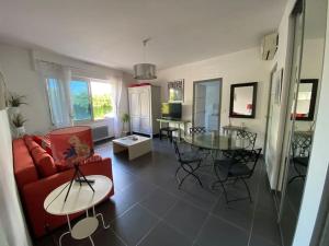 波爾多的住宿－Appartement 45m2 à Bordeaux avec accès piscine，客厅配有红色的沙发和桌子
