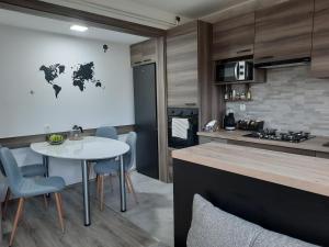 eine Küche mit einem weißen Tisch und Stühlen sowie einer Theke in der Unterkunft Apartman Ines in Velika Gorica