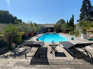 - une piscine avec 2 chaises et une table à côté dans l'établissement Appartement 45m2 à Bordeaux avec accès piscine, à Bordeaux
