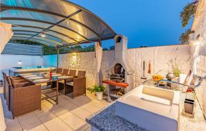 un patio al aire libre con mesa y chimenea en Beautiful Home In Kavran With Kitchen, en Kavran