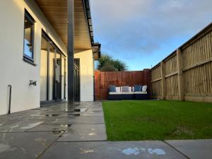 a backyard with a couch in a fence at Surfers Lodge - Rest Bay, Porthcawl in Porthcawl