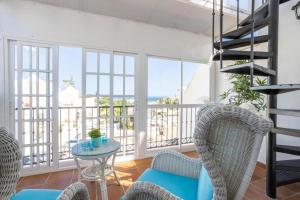 uma sala de estar com cadeiras, uma mesa e uma varanda em Shangri-La Punta Lara em Nerja