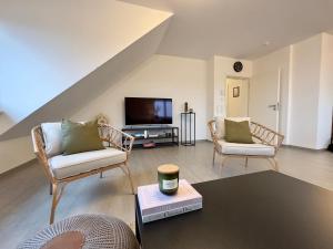 sala de estar con 2 sillas y TV en Moderne Wohnung mit Küche & Parkplatz Ausblick auf den bayerischen Wald 