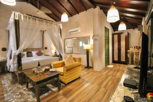 um quarto com uma cama, um sofá e uma mesa em Oxygen Resorts Morjim, Goa em Morjim