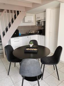 サン・ジャン・ド・モンにあるLe Cosy d'Edenのキッチン(黒いテーブル、椅子付)