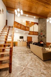 una gran sala de estar con escalera y chimenea en Tales N Trails, en Bashist