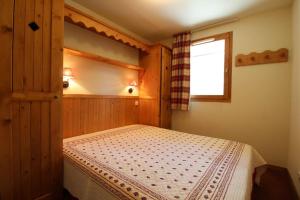 a bedroom with a bed in a room with a window at "Alpages de Val Cenis"-Skis aux pieds-Spa-Wifi-Garage-Calme! in Lanslebourg-Mont-Cenis