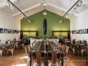 a room with tables and chairs and a green wall at Matador Lodges in Grabenstätt