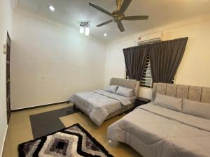 a bedroom with two beds and a ceiling fan at D'Village Batu Berendam, Melaka in Ayer Keroh