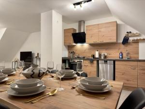 una mesa de madera con platos y copas de vino. en Moderne Wohnung mit Küche & Parkplatz Ausblick auf den bayerischen Wald 