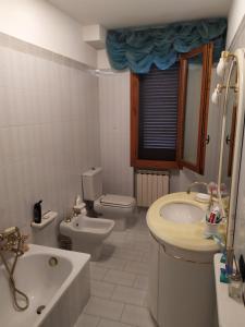 a bathroom with a toilet and a sink and a tub at Casa Chiantishire in Montespertoli