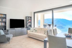 een woonkamer met een bank, een tafel en een televisie bij THE VIEW!!! by Design Studio in Perledo