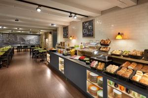 a bakery with a long counter with bread and pastries at Nova Hotel in Amsterdam