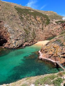 a beach next to a mountain with a body of water at BerlengaBed&Breakfast in Peniche