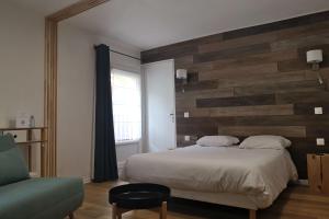 1 dormitorio con 1 cama y pared de madera en Hôtel Les Castets d'Ayré en Barèges