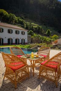 a table and two chairs with drinks on a patio at Solar dos Reis by An Island Apart in Ribeira Brava