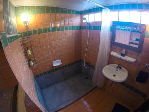a bathroom with a shower and a sink at The Riverside Guest House in Lampang