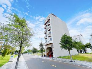 a tall white building on the side of a street at Sea Star Hotel in Phan Thiet