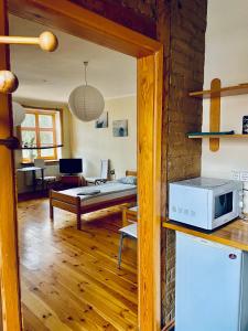een keuken met een magnetron en een woonkamer bij Express Guest House in Klaipėda