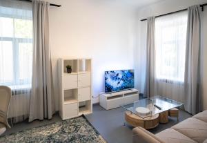 a living room with a couch and a tv at Arida Apartments in Rīga