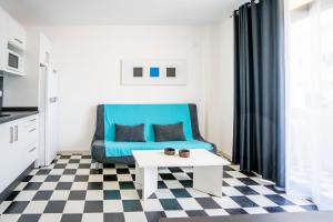 ein Wohnzimmer mit einem blauen Sofa und einem Tisch in der Unterkunft Mirada II - Formentera Break in Es Pujols
