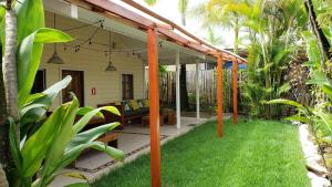 an outdoor patio with awning and green grass at Pineapple House in Bocas Town