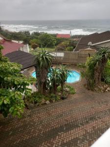an aerial view of a resort with a swimming pool and the ocean at Dolphin Den in Port Shepstone