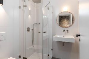 bagno con doccia, lavandino e specchio di Industrial 42sqm 3room maisonette apt near center a Berlino