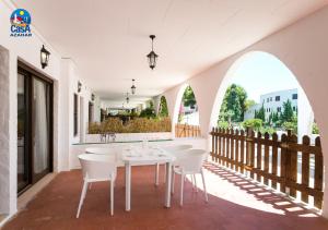 uma sala de jantar com uma mesa branca e cadeiras em Apartamentos Arcos I Superior Casa Azahar em Alcossebre