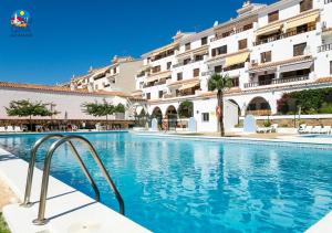 a swimming pool in front of a building at Apartamentos Arcos I Superior Casa Azahar in Alcossebre