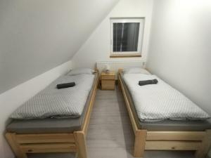 twee bedden in een kleine kamer met een raam bij Rekreačný dom pod Smrekovom in Lúčky