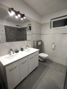 een badkamer met 2 wastafels en een toilet bij Rekreačný dom pod Smrekovom in Lúčky