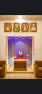 a man sitting on a stage in a room at Saish Hotel Shirdi in Shirdi